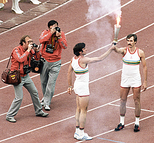 Виктор Санеев передает олимпийский факел Сергею Белову